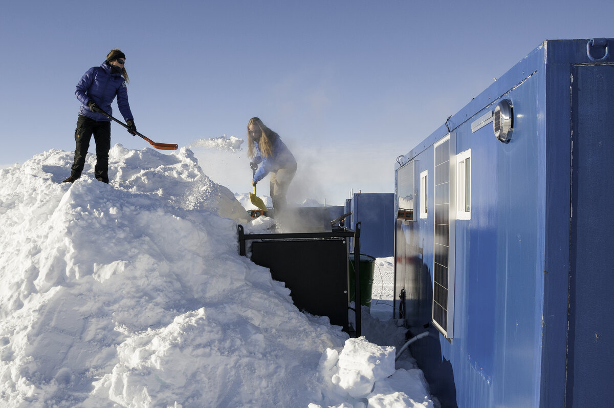 Hotel Services staff shovel snow into the shower snow melter